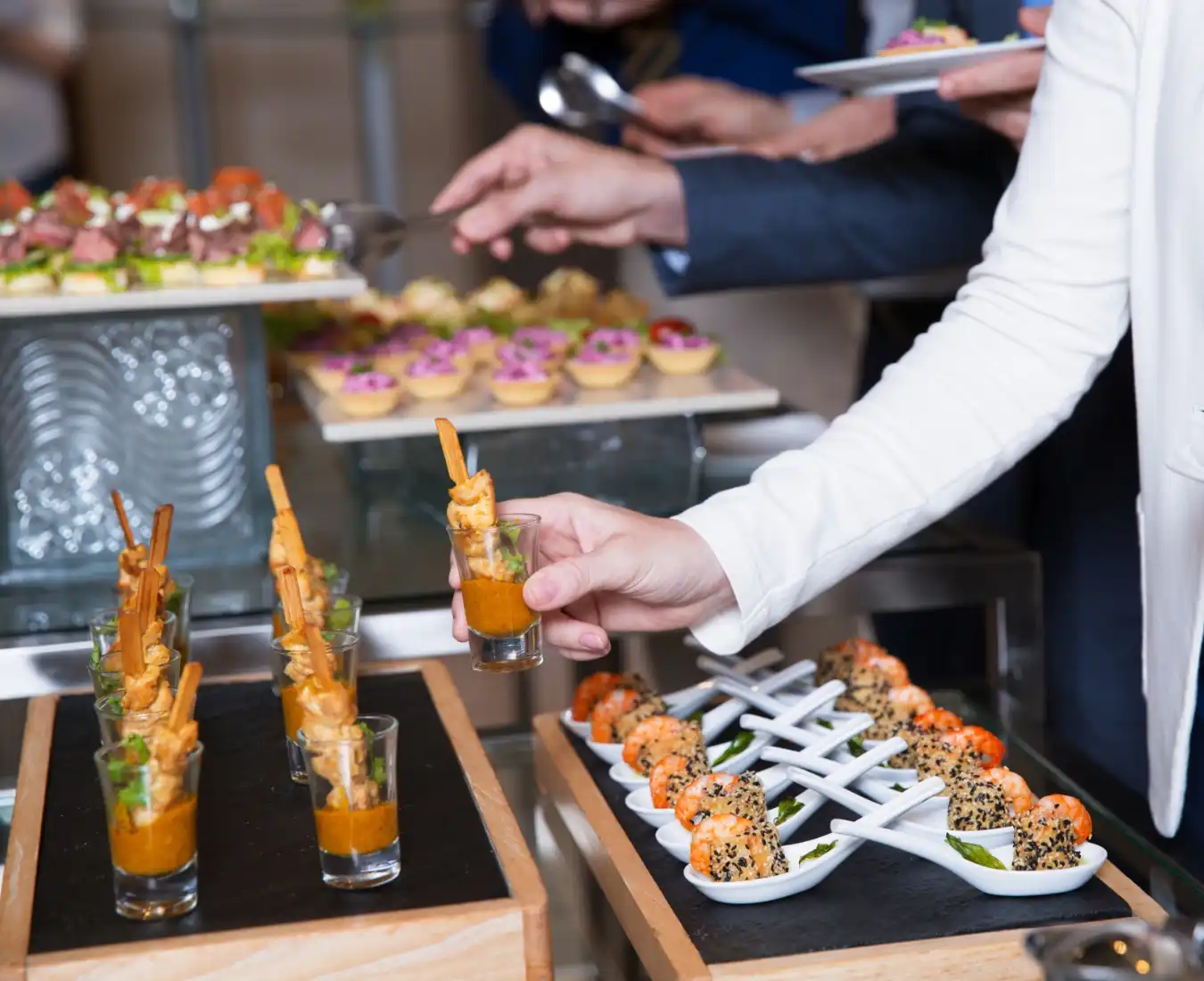 Elegant gourmet catering event in a luxury Washington DC ballroom with guests and servers enjoying fine cuisine.